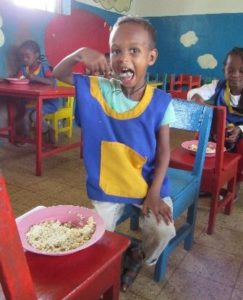 Seguridad alimentaria: niño de uno de los centros disfrutando de un plato de arroz con verduras